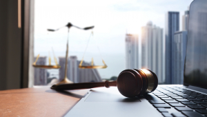 A judge's gavel lying on a computer